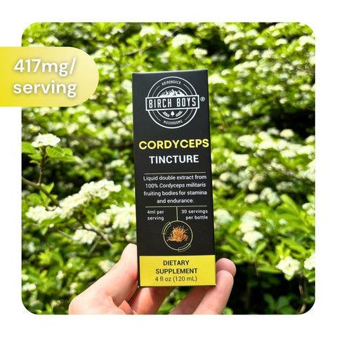Birch Boys Cordyceps Tincture box outside in front of flowers. Text in the corner reads "417 mg/serving"