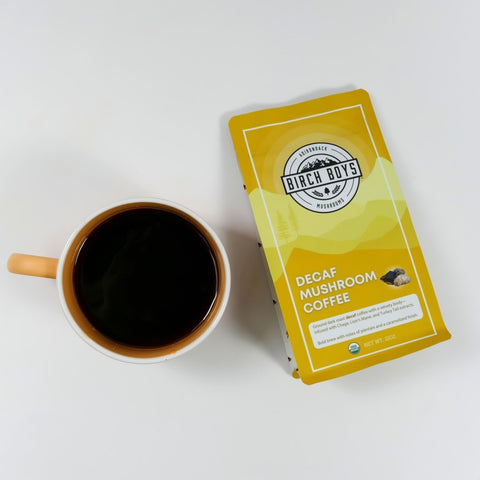 A mug of coffee next to a bag of Birch Boys Decaf Mushroom Coffee
