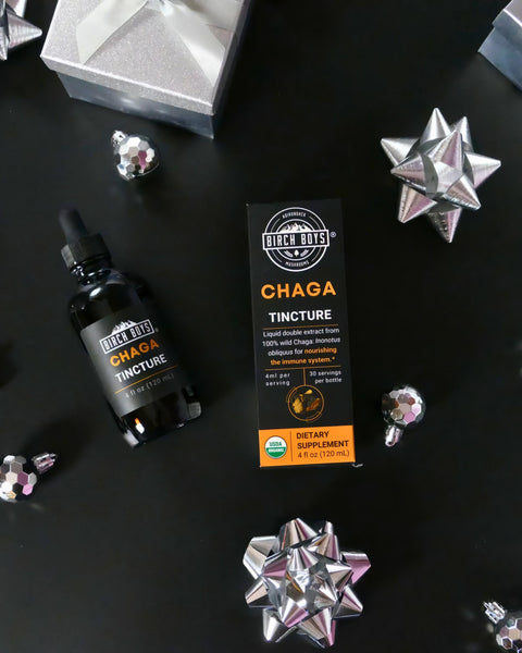 Chaga tincture bottle and packaging on a dark surface with decorative stars.