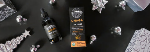 Birch Boys Chaga tincture bottle and packaging on a dark surface with decorative holiday elements.