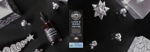 Lion's Mane Tincture bottle with packaging on a dark surface with decorative items.