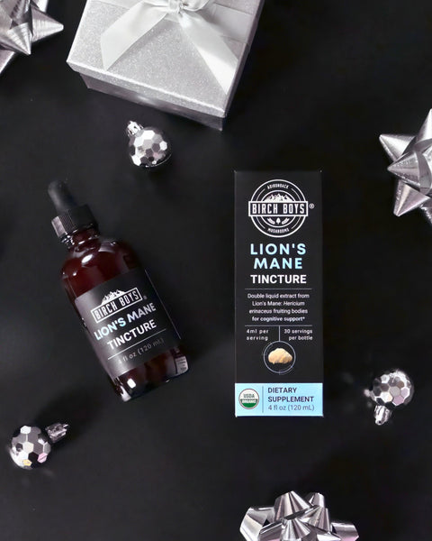 Lion's Mane Tincture bottle and packaging on a dark surface with decorative silver elements.