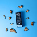 Black Boys Lions Mane Tincture box surrounded by lion's mane mushrooms on a blue background