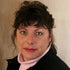 Gift wrap portrait of a woman with short dark curls wearing a light pink turtleneck.