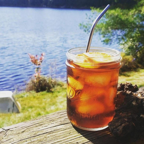 Mason jar with iced chaga tea by a lakeside