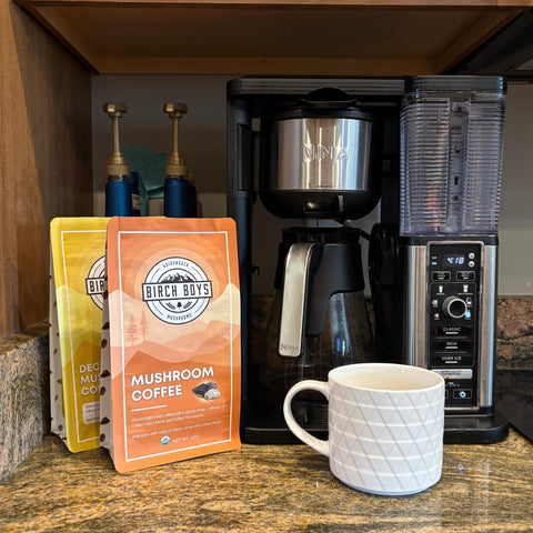 Birch Boys Mushroom Coffee package next to a coffee maker and mug on a countertop