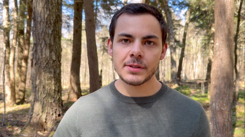 Gift wrap showing a man wearing a gray crewneck sweater outdoors