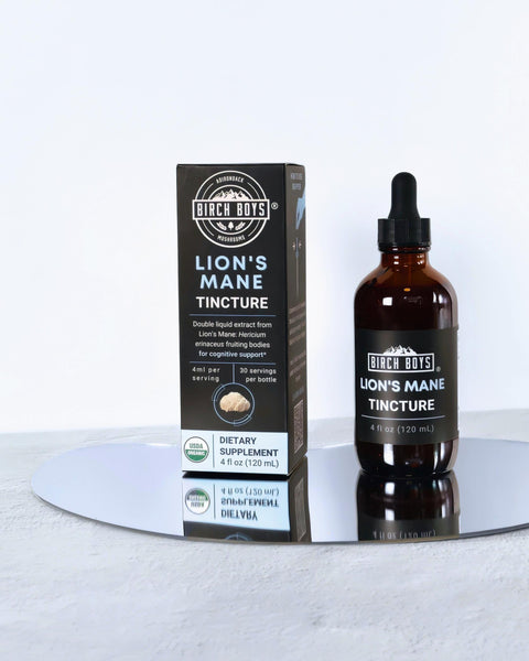 Lion's Mane Tincture bottle and packaging on a reflective surface with a white background