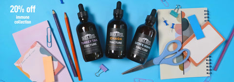 Immune supporting tinctures on a blue background with stationery items.