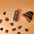 Chaga tincture, chunks of chaga and a chaga conk on a bright orange background