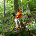 Man holds large chaga conk in a birch forest